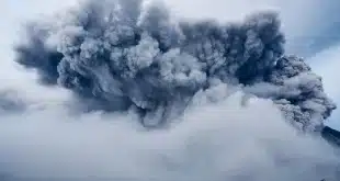 Visiteurs anonymes marchant parmi fondations arasées et collines volcaniques en plein jour