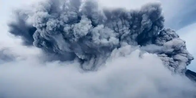 Visiteurs anonymes marchant parmi fondations arasées et collines volcaniques en plein jour