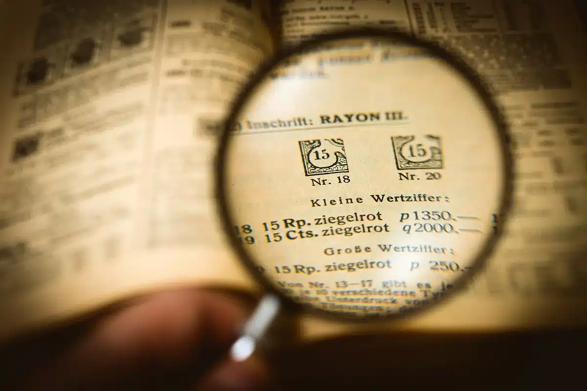 Personne anonyme examinant un contrat d'assurance avec une loupe