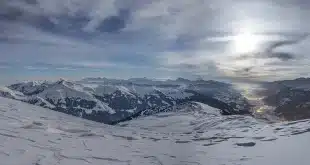 Paire de skis et télésiège sur une piste panoramique ensoleillée