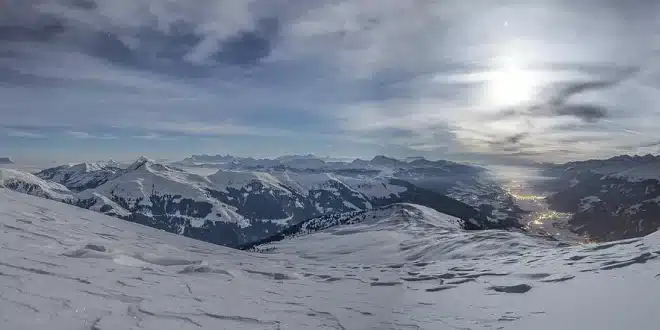 Paire de skis et télésiège sur une piste panoramique ensoleillée