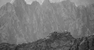 Corniche rocheuse et crique méditerranéenne avec mains tenant une carte