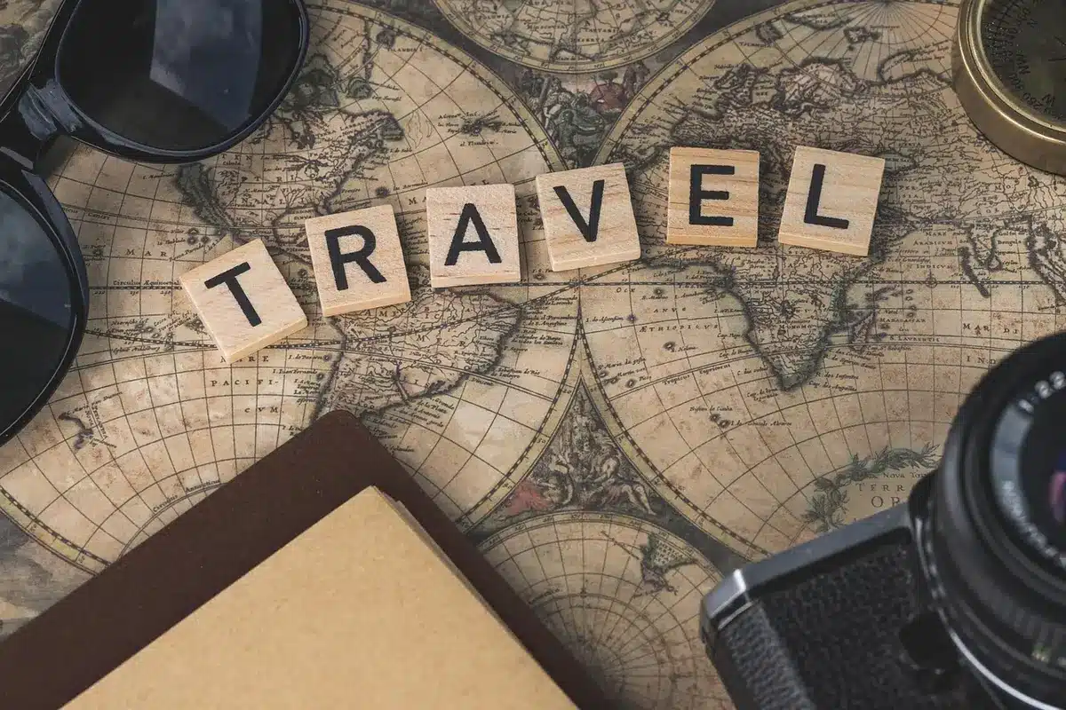 Carte et carnet de voyage posés sur une table pour planifier un circuit en Normandie