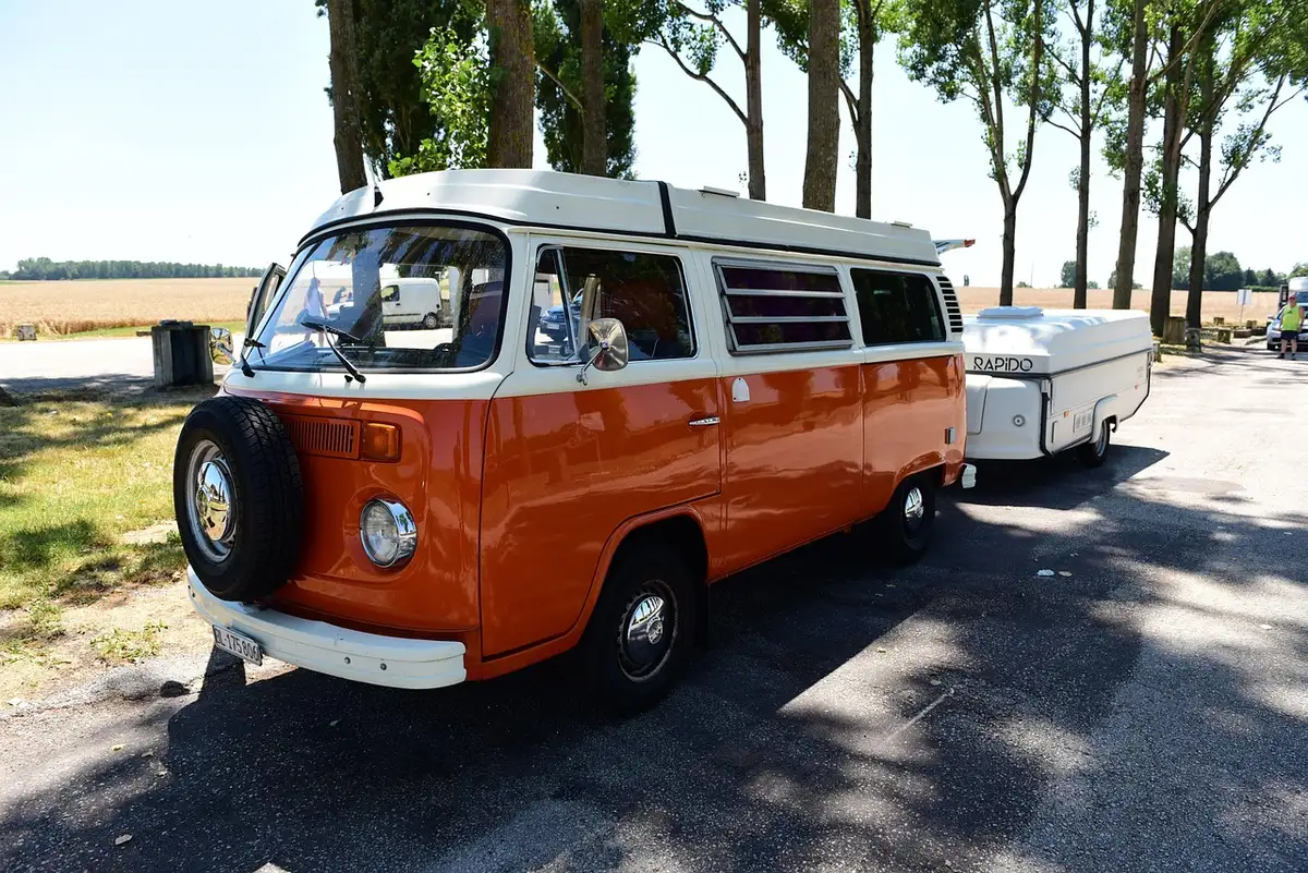 Van aménagé garé dans un camping en plein jour près de la nature