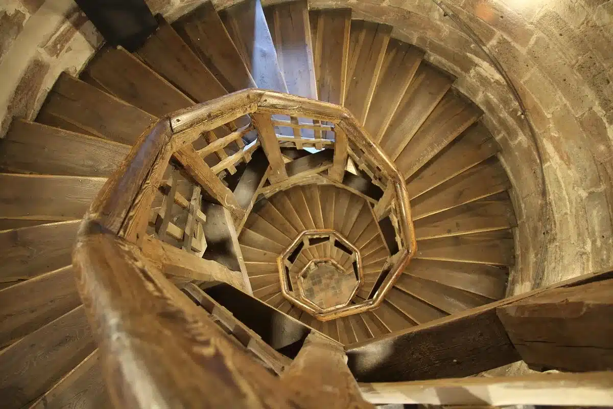 Escaliers métalliques et visiteurs montant vers un étage intermédiaire de la tour
