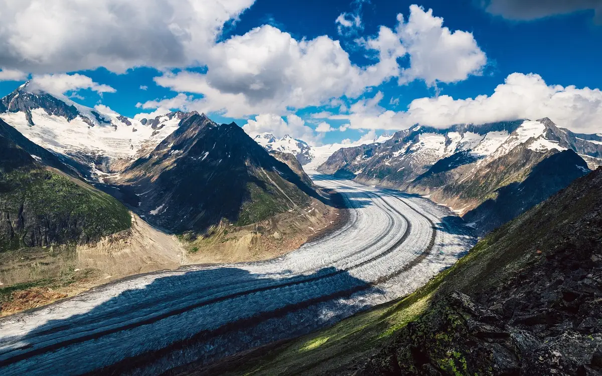 Panorama d'un lac entouré de parois rocheuses et de montagnes
