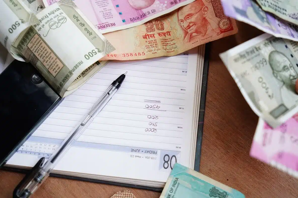 Personne préparant un budget de voyage avec documents et calculatrice