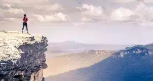 Vue diurne depuis la fenêtre d'un van sur une route de campagne et falaises au loin