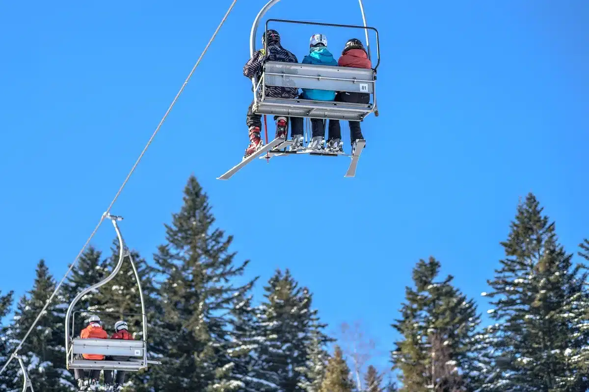 Rue piétonne du village des Gets avec commerces et montagnes enneigées