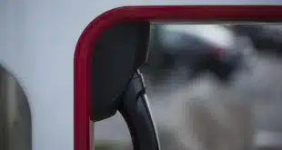 Voiture électrique garée près d'une borne sur une aire de repos, jour ensoleillé