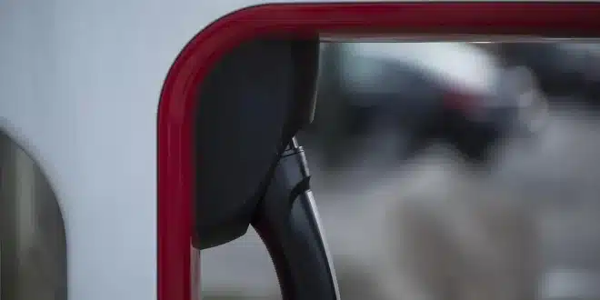 Voiture électrique garée près d'une borne sur une aire de repos, jour ensoleillé