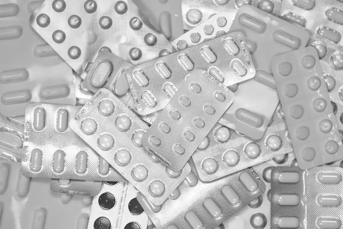 Documents d'assurance et médicaments sur une table, vue anonyme