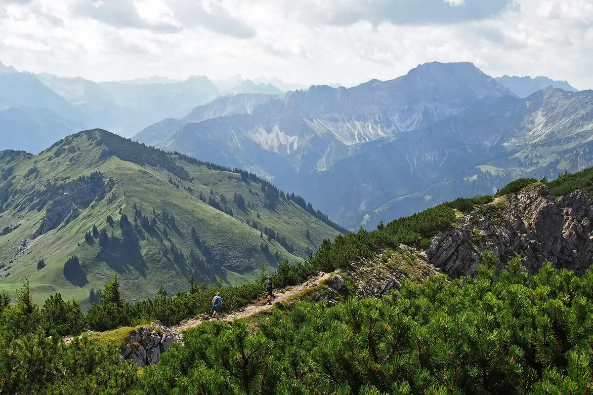 Randonneur anonyme sur un sentier de montagne corse avec panorama rocheux