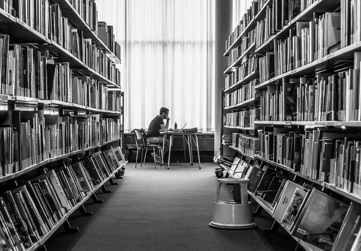 Personne anonyme étudiant des phrases dans un carnet avec une application de langue ouverte