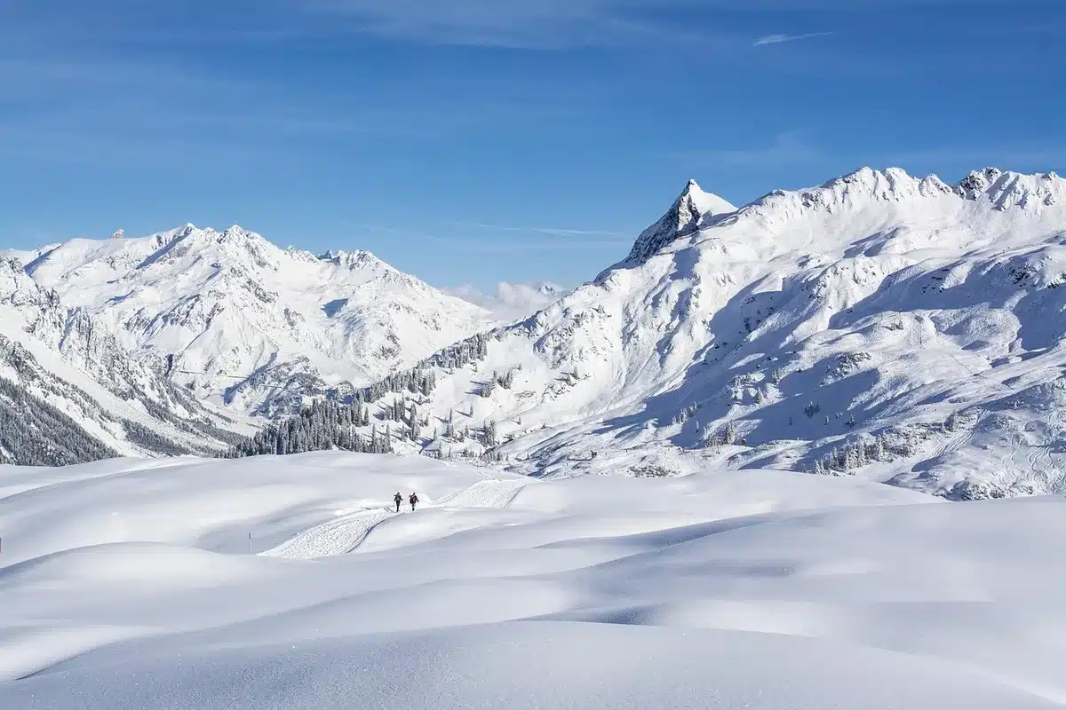 Local à skis près d'une entrée d'hébergement avec poussette à côté
