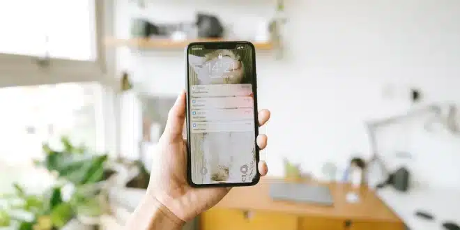 Mains anonymes avec smartphone montrant une notification de vol près d'une valise à l'aéroport