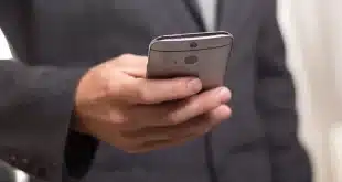 Smartphone sur une table d'aéroport avec passeport et valise en arrière‑plan