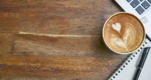Voyageur anonyme utilisant un smartphone et un ordinateur portable dans un café