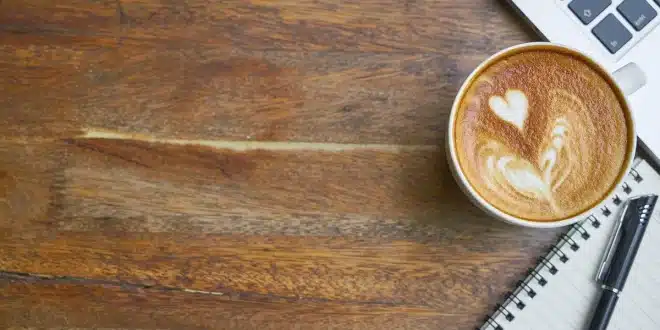 Voyageur anonyme utilisant un smartphone et un ordinateur portable dans un café