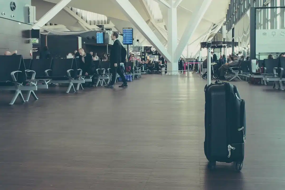 Hall d'embarquement spacieux avec panneaux de départ et passagers anonymes