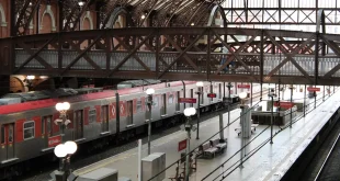 Quai de gare italien au petit matin avec une valise et un panneau d'horaires générique