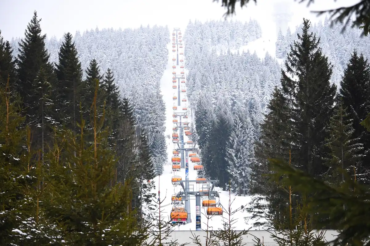 Tyrolienne au‑dessus d'un domaine skiable avec montagnes en arrière‑plan