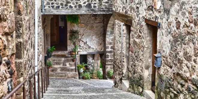 Promenade anonyme sur une rue pavée d'Avignon, façades médiévales et terrasses floues