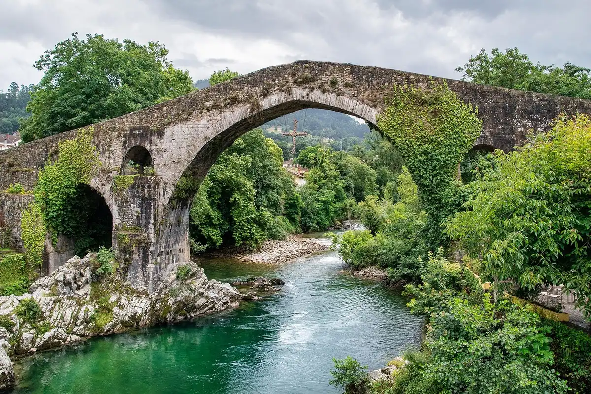 Brantôme vu depuis la rivière avec pont en pierre et berges animées