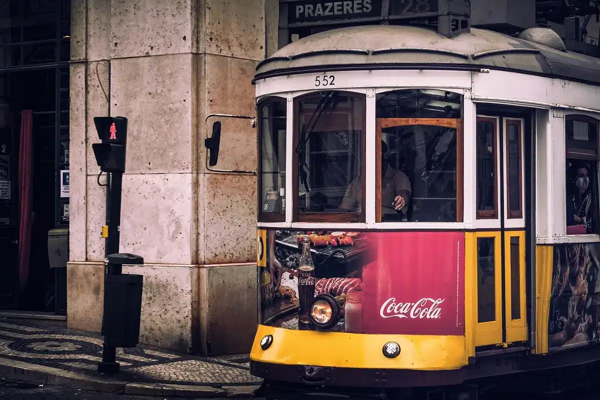 Tramway ancien dans une rue escarpée de Lisbonne avec mirador au loin