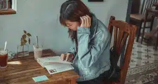 Table de café en journée avec carte de voyage et mains feuilletant des brochures