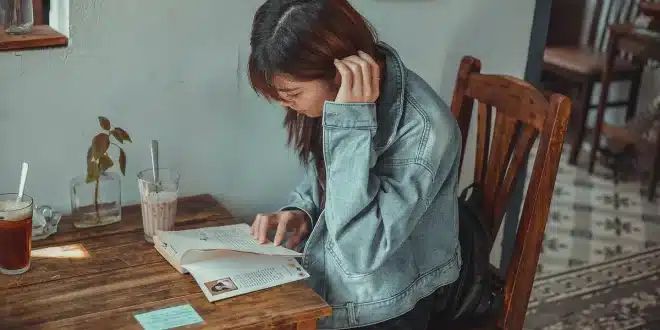 Table de café en journée avec carte de voyage et mains feuilletant des brochures