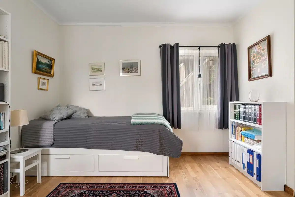 Chambre et coin cuisine d'un appartement adapté aux familles, avec lits séparés