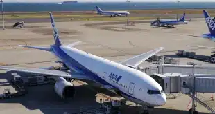 Sièges d'aéroport proches d'une grande baie vitrée, valise à côté, lumière du jour