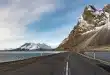 Chemin côtier islandais en plein jour avec roches de lave et randonneurs anonymes