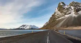 Chemin côtier islandais en plein jour avec roches de lave et randonneurs anonymes