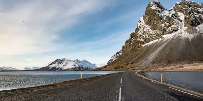 Chemin côtier islandais en plein jour avec roches de lave et randonneurs anonymes