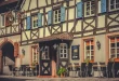 Cour ensoleillée d'un hébergement familial avec terrasse et espace de jeux près d'une lisière de forêt