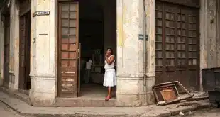 Rue pavée ensoleillée dans la vieille ville de Carthagène avec façades coloniales et passants anonymes