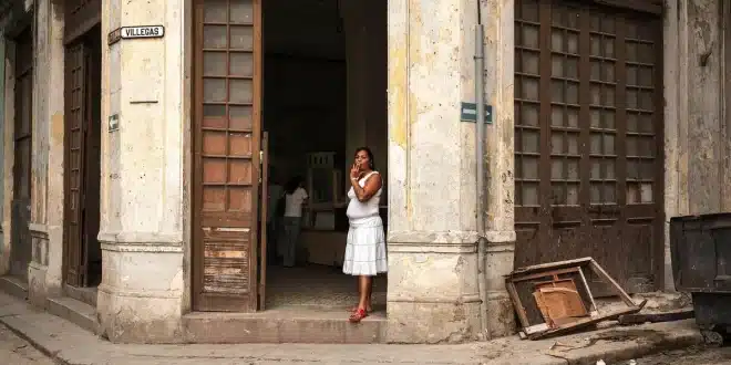 Rue pavée ensoleillée dans la vieille ville de Carthagène avec façades coloniales et passants anonymes