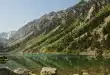 Table de pique-nique au bord d'un lac pyrénéen avec carte et gourde, en plein jour