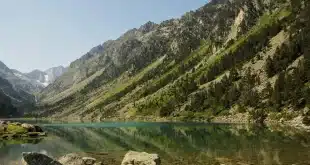 Table de pique-nique au bord d'un lac pyrénéen avec carte et gourde, en plein jour