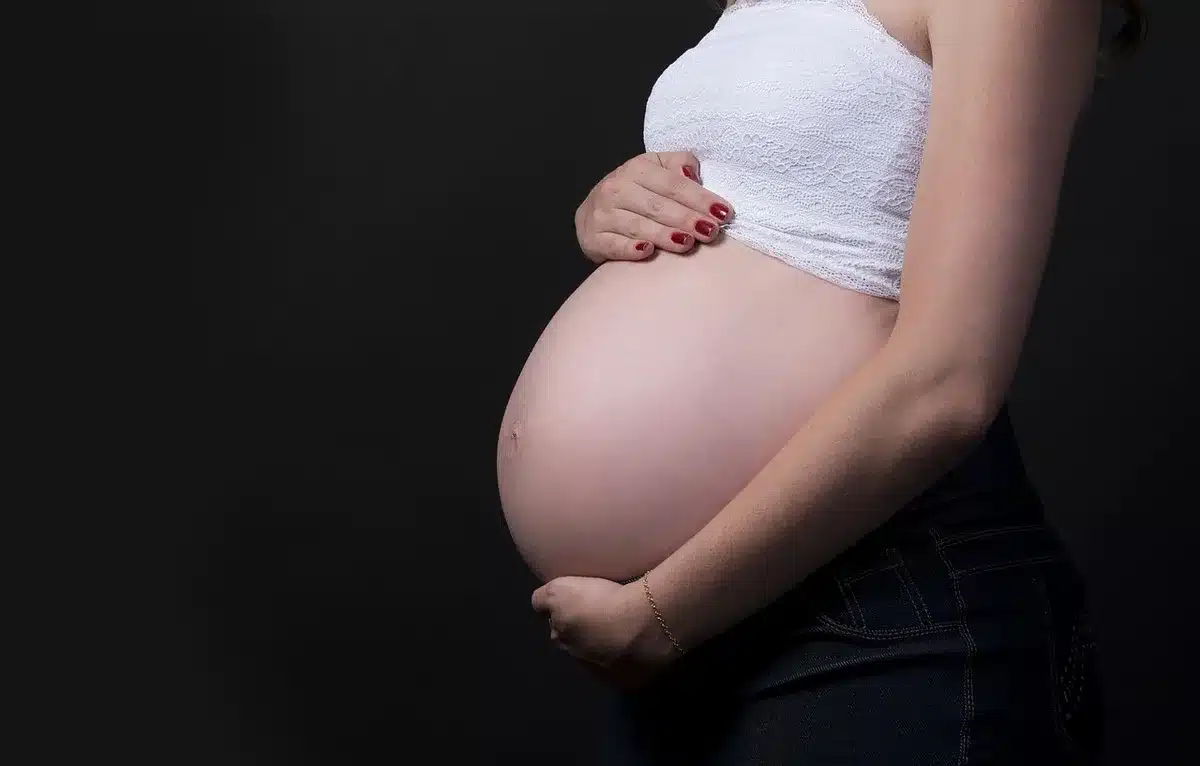 Consultation prénatale : femme enceinte montrant son carnet de grossesse au médecin