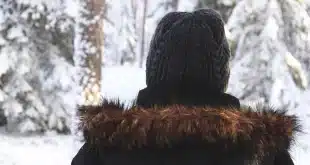 Valise ouverte près d'une fenêtre avec vêtements techniques, veste et chaussures d'hiver