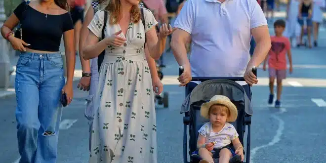 Poussette et bagages sur un trottoir en ville, journée ensoleillée