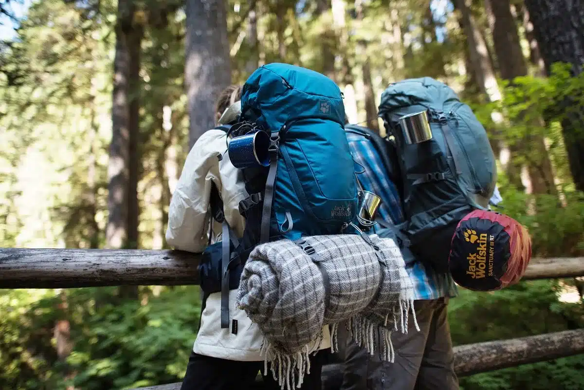 Sac à dos, lampe frontale et veste posés sur un rocher avant une visite de grotte